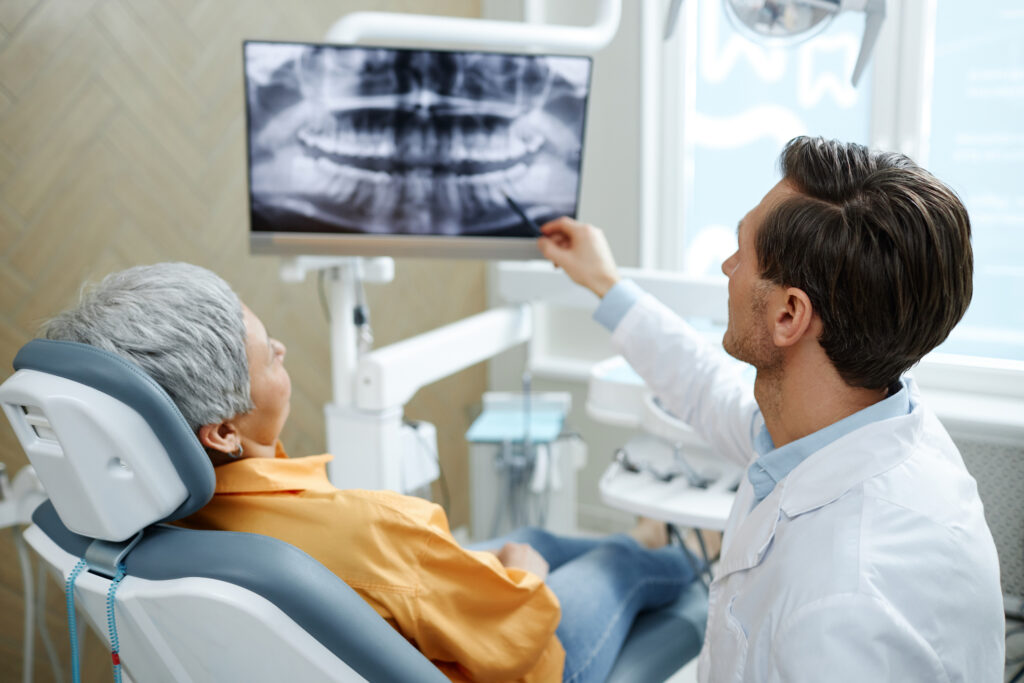 Dentist explaining dental implant procedure during patient consultation in East Longmeadow Massachusetts